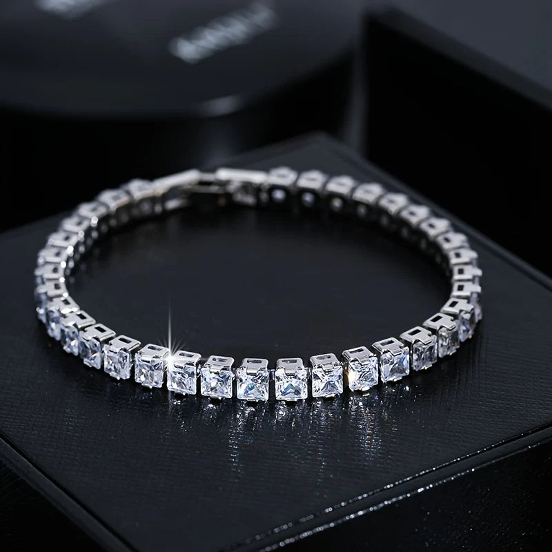 Silver bracelet with clear gemstones on a black surface