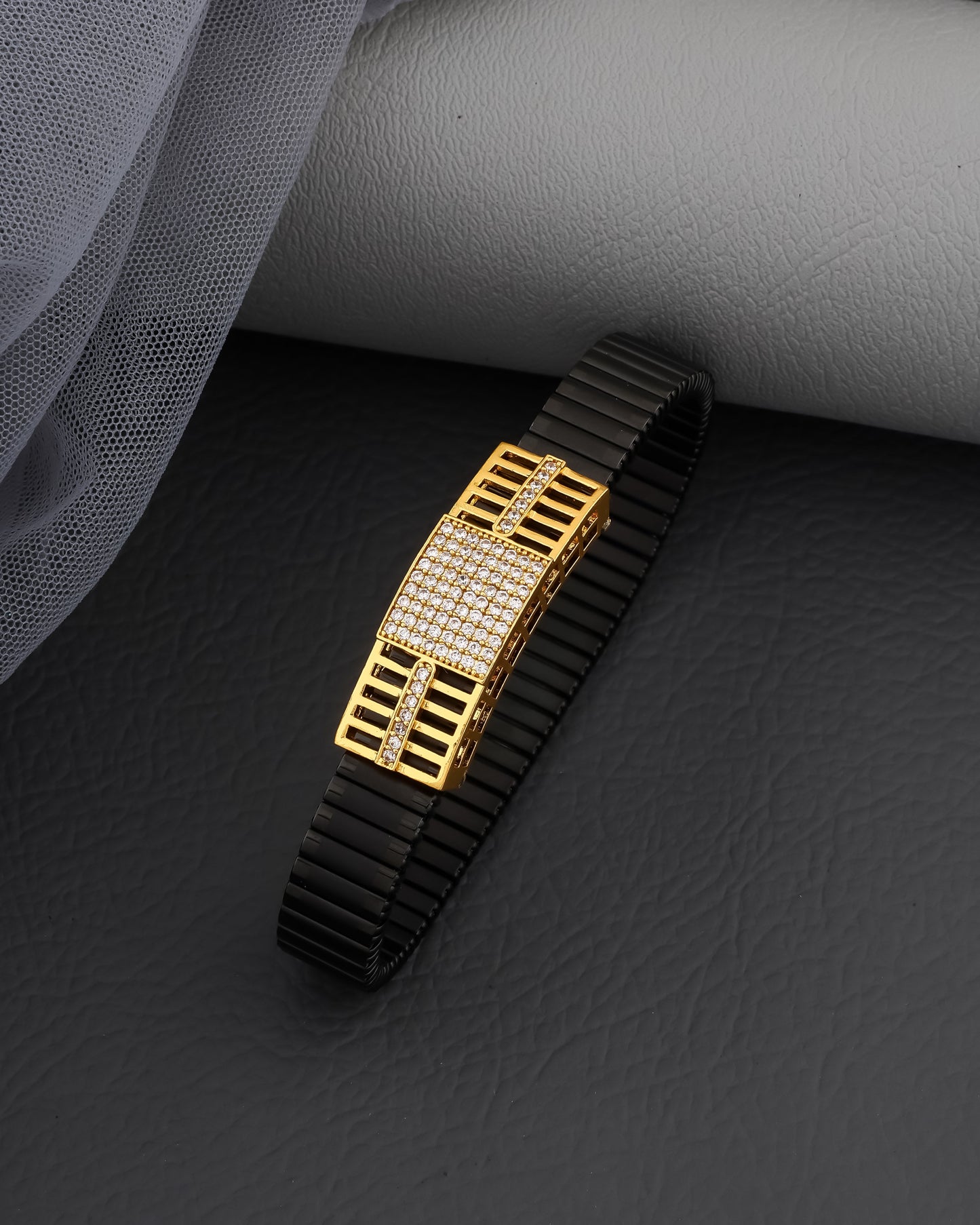 Black and gold bracelet on a dark surface