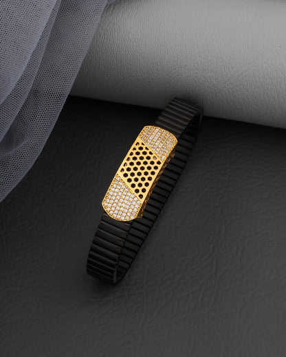 Black and gold watch strap on a dark surface with gray fabric background