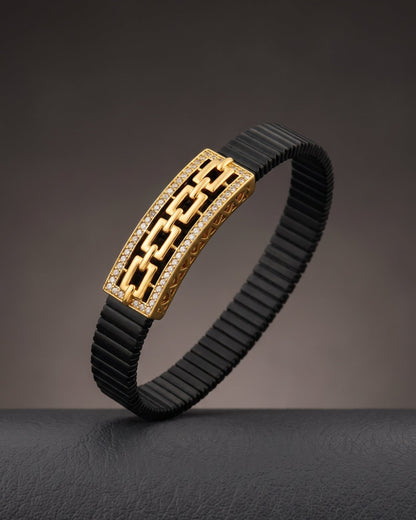 Black rubber bracelet with gold clasp on a dark background