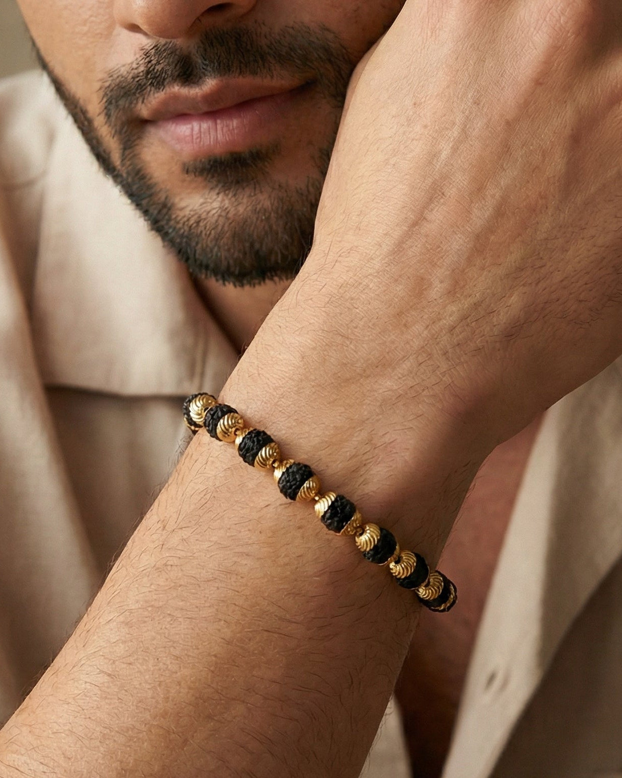 Man wearing a bracelet on his wrist with a neutral background