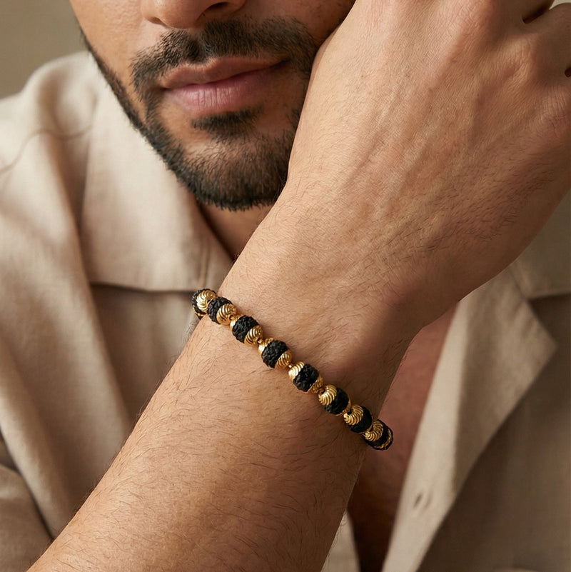 Man wearing a bracelet on his wrist with a neutral background